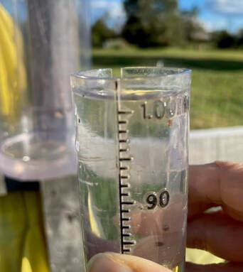 close up photo of a person's hand holding a rain gauge